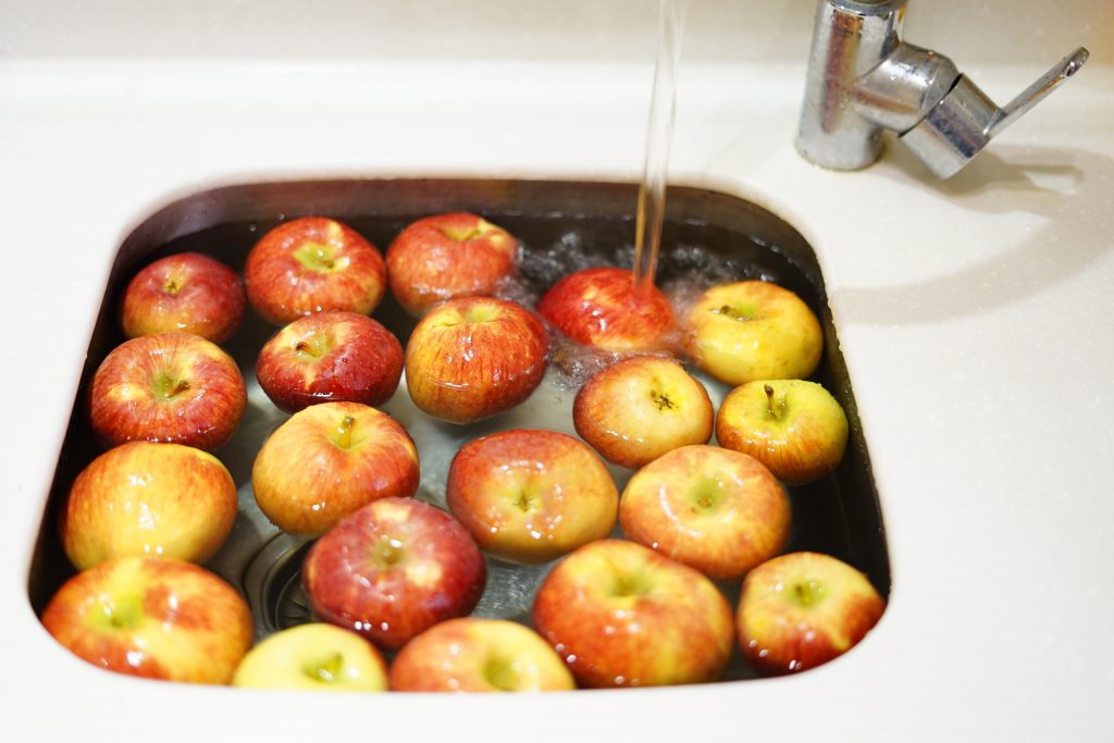 Photo of apples being washed in a sink