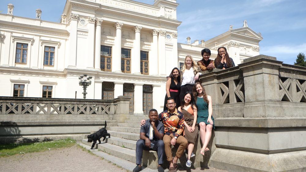Development studies class sitting in front of the main university building