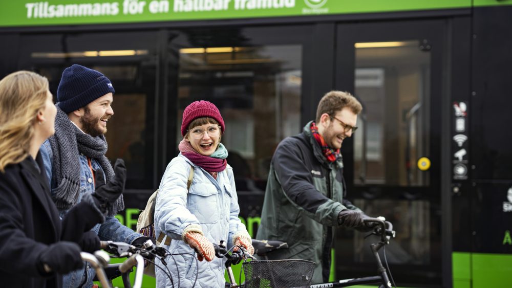 Students walking walking, pulling their bikes, talking and laughing together